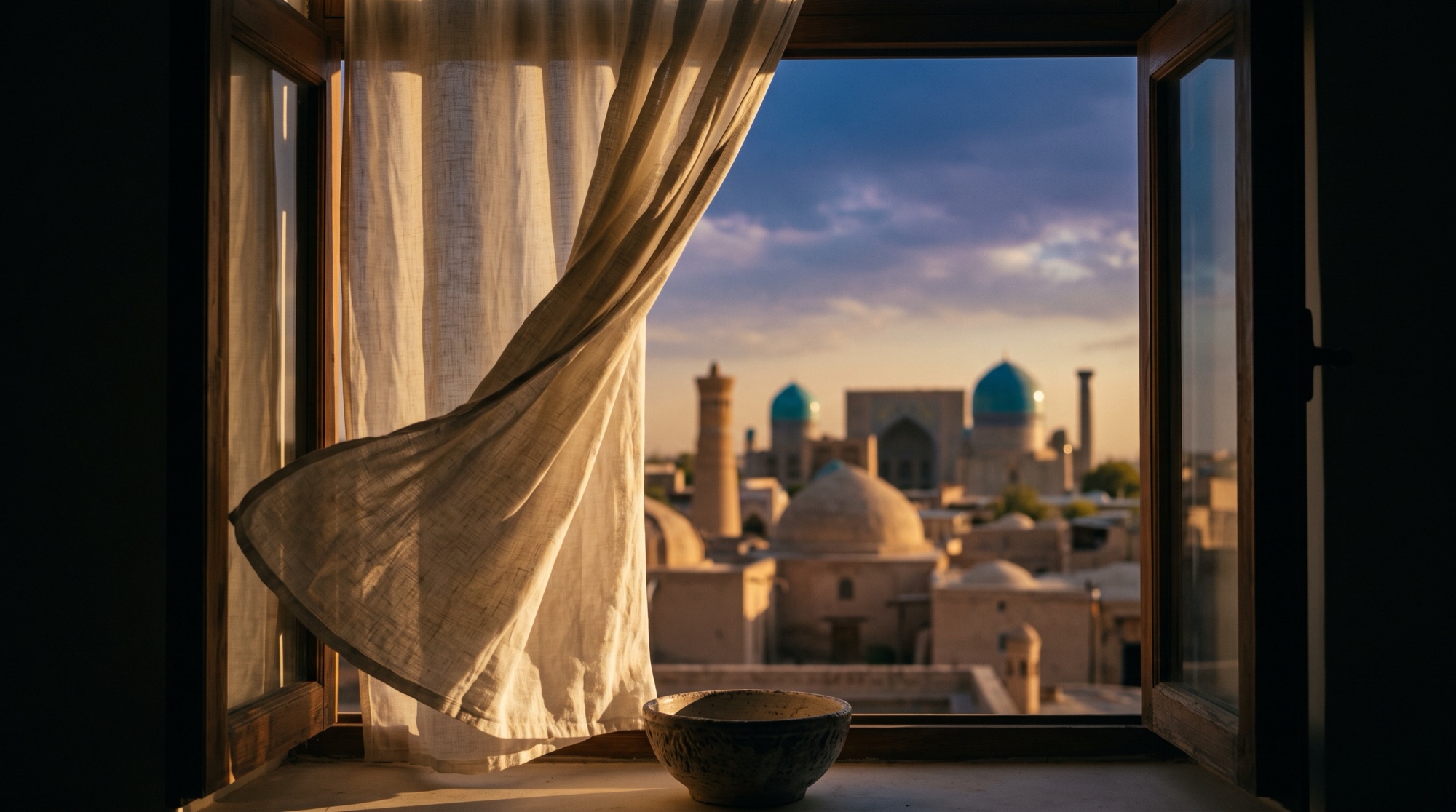 An open window with a linen curtain over the domes and minaret of an old city at dusk