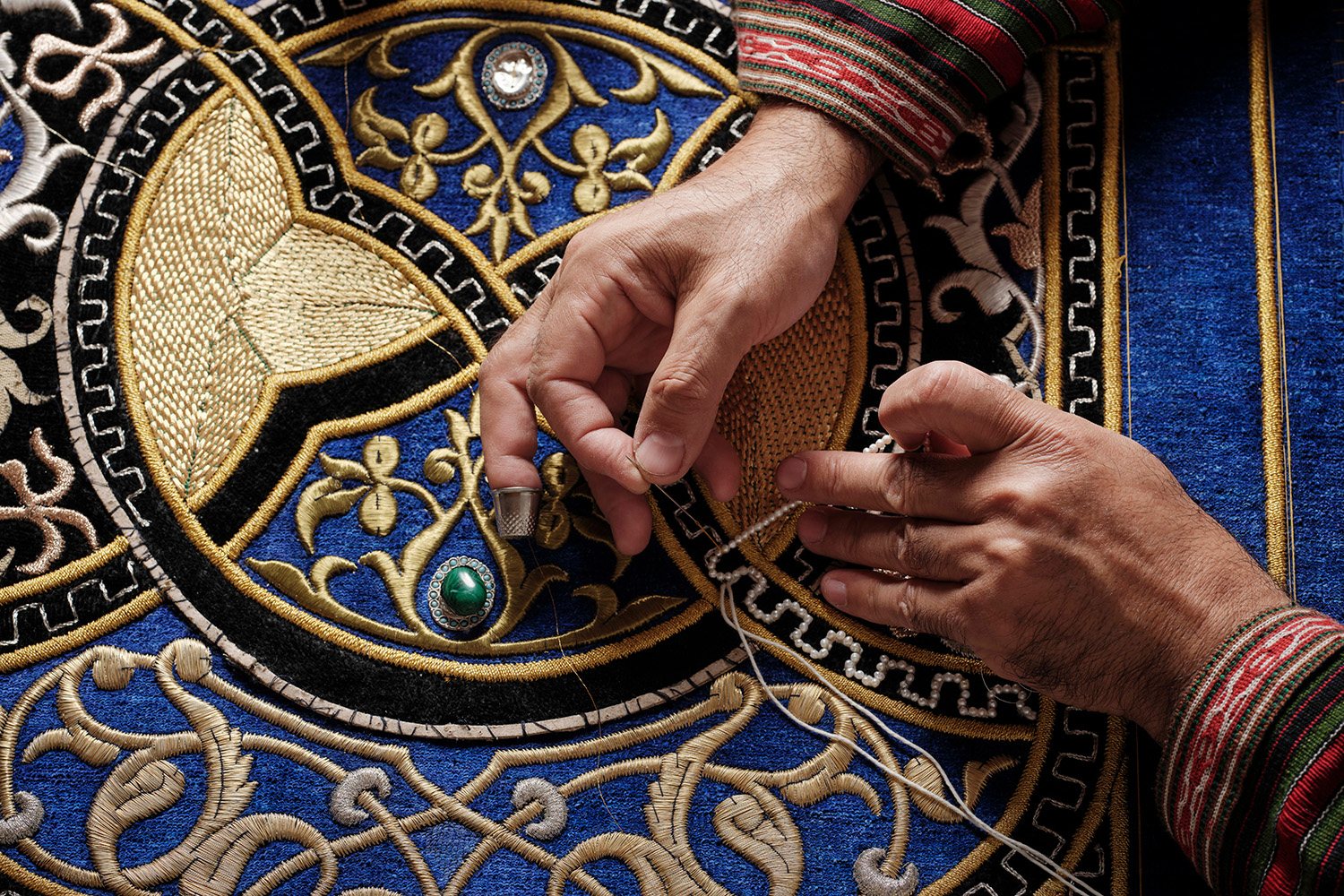 Hands preparing gold thread